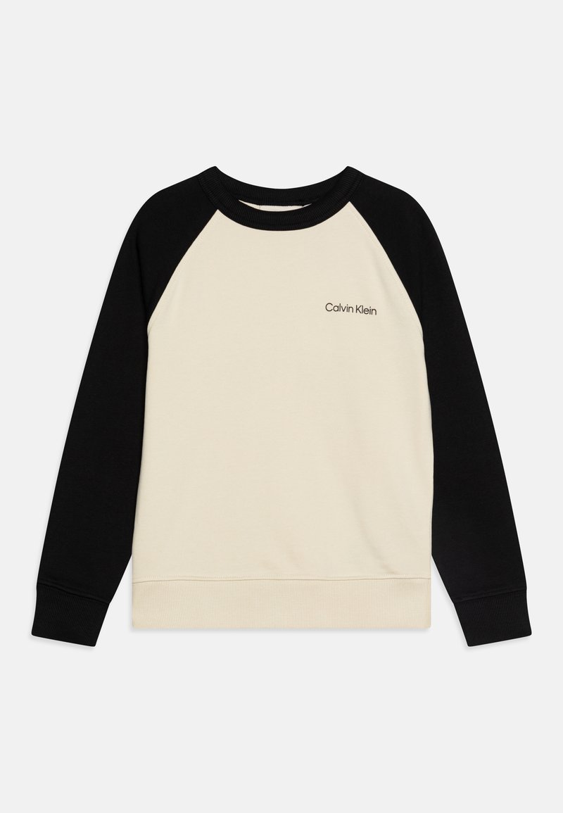 Kremowa i czarna bluza raglanowa z rypsowym kołnierzem i mankietami; posiada małe logo na piersi. Gładki materiał o delikatnej strukturze.