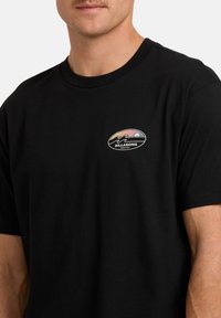 Zwart katoenen t-shirt met een klein, kleurrijk Billabong-logo op de linkerborst, met een ontwerp van golven en een zonsondergang. Korte mouwen, ronde hals.
