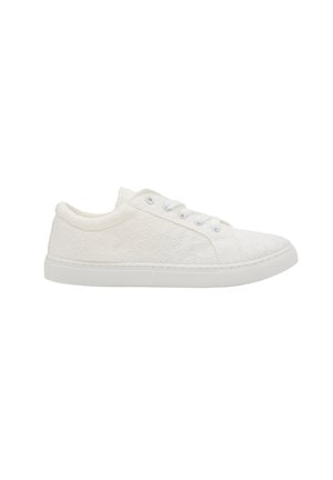 Zapatilla baja blanca con patrón de encaje, cordones blancos y suela de goma sobre un fondo blanco liso.