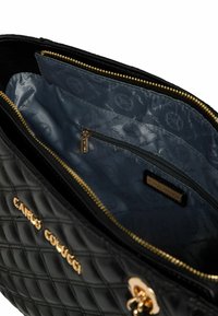 Schwarze gesteppt Lederhandtasche mit goldfarbenen Beschlägen. Innenausstattung mit blau gemustertem Futter und einer Reißverschlusstasche. Markenname außen geprägt.