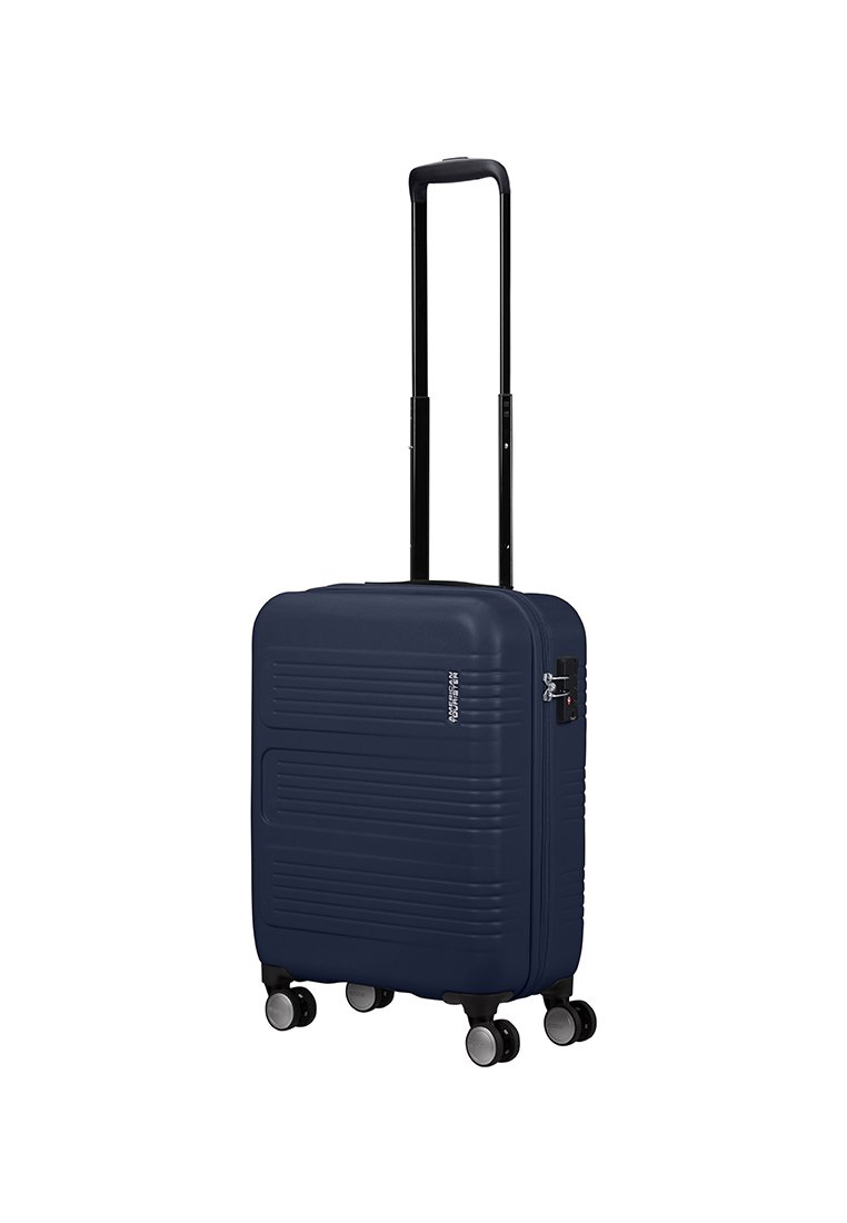 Valigia rigida blu navy con scanalature orizzontali, manico retrattile nero, quattro ruote e lucchetto a combinazione sul lato.