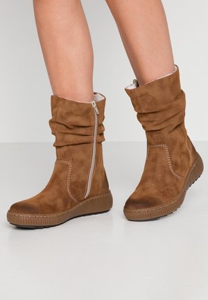 Bottes à chevilles en suède marron au design loose, avec détail de fermeture éclair et semelle en caoutchouc texturée. Intérieur doublé pour un confort supplémentaire.
