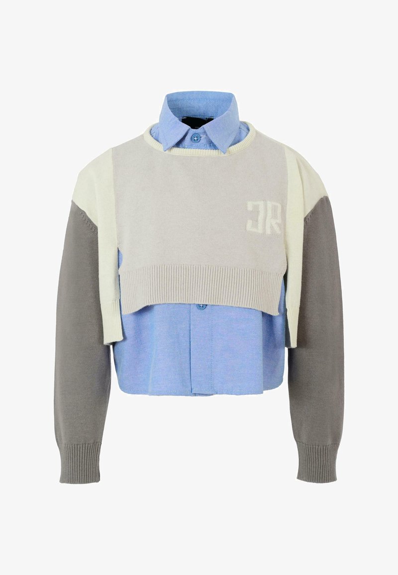 Maglione corto stratificato con parte superiore tricot grigio chiaro, accenti beige e una camicia colletto azzurra sottostante, con dettagli sui bottoni.
