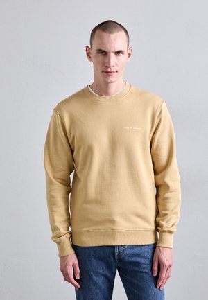 Light beige sweatshirt featuring a crew neck, long sleeves, and ribbed cuffs. The front displays the text "TIGER OF SWEDEN" in white.