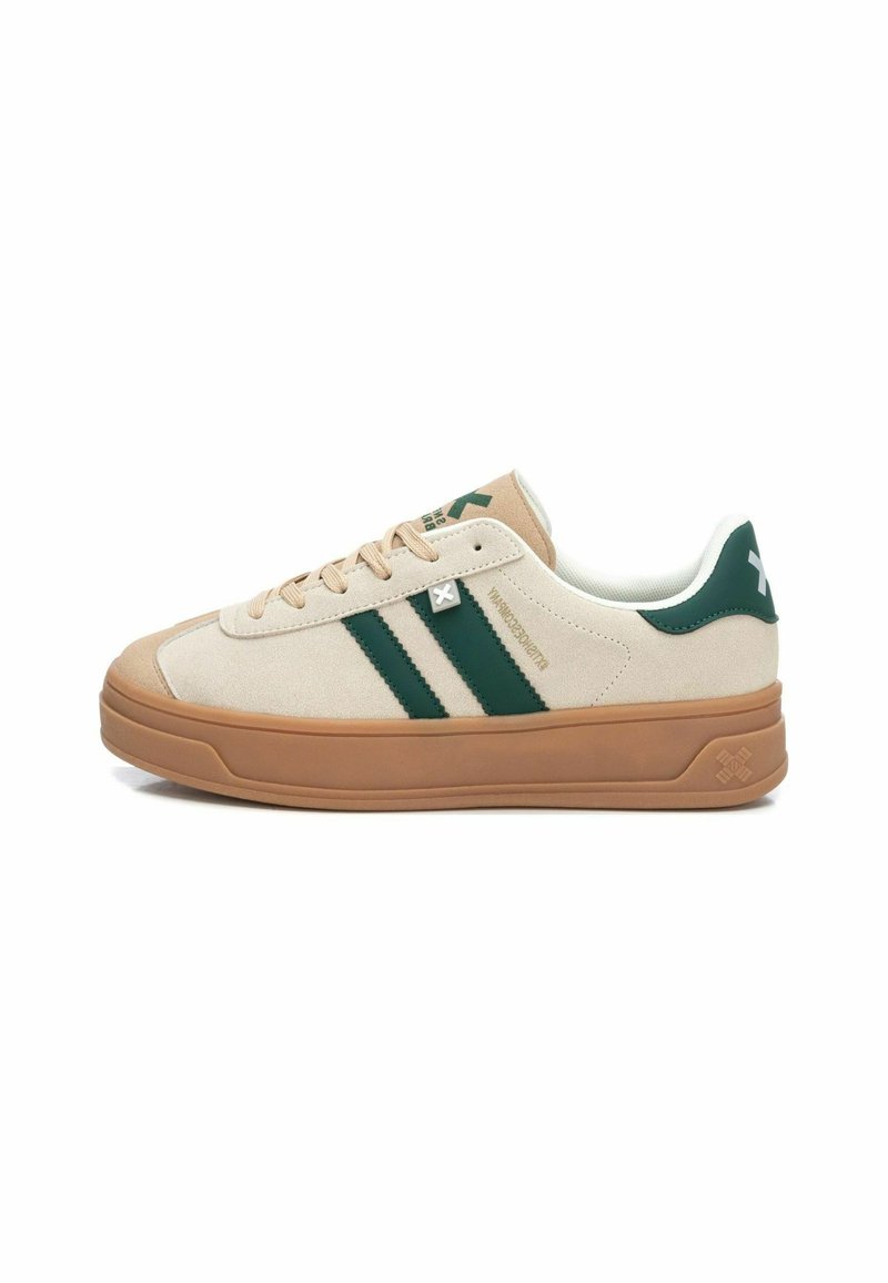 Zapatillas de ante beige con rayas verdes, suela de goma y cuello acolchado. Presenta un logo cerca de los cordones y acentos texturizados en la suela.