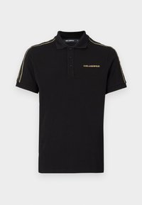 Svart polo-shirt i bomull, med en treknapplång placket, korta ärmar och guldaccenter på axlarna och logotypen.