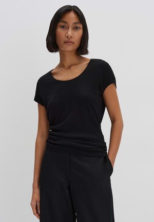 Top nero a maniche corte con scollo rotondo, realizzato in tessuto a costine. Presenta una vestibilità rilassata e una trama delicata. Abbinalo a pantaloni neri.