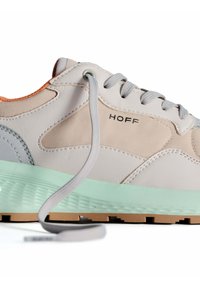 Zapatilla ligera con una combinación de materiales en crema y verde menta. Presenta un upper suave y texturizado, cordones grises y un sutil detalle del logotipo.