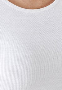 Canottiera bianca a coste con scollatura rotonda, texture morbida e design aderente. Il materiale sembra elastico e confortevole.