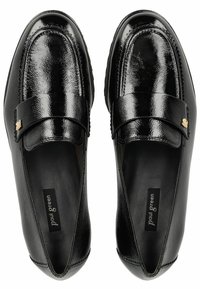 Zwarte leren instappers met een glanzende afwerking, voorzien van een decoratieve band en gouden accenten. Soepel van structuur met een afgeronde neus.