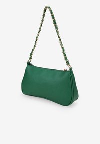 Bolso de mano de cuero verde con forma curva y acabado texturizado, que presenta una correa de cadena con acentos dorados. Cierre de cremallera en la parte superior.