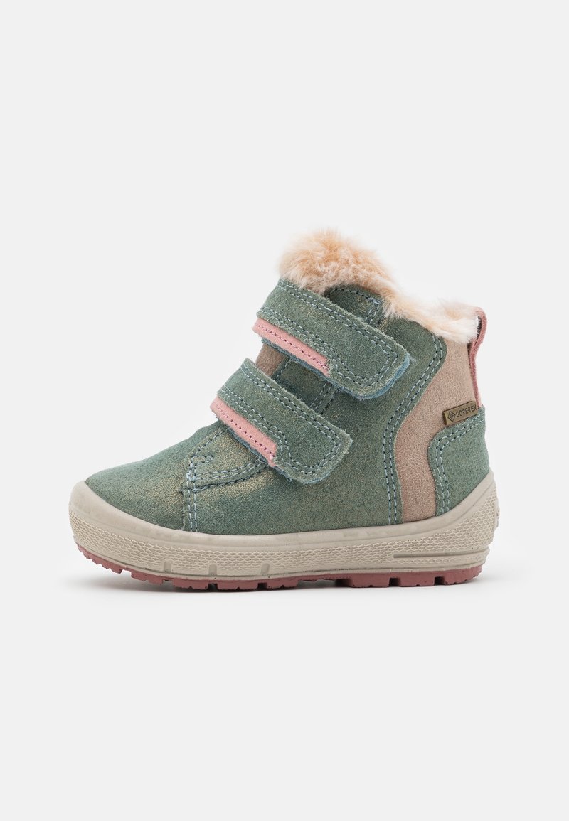 Bottine en daim vert avec deux bandes Velcro roses, doublure en fausse fourrure, accents en daim beige et semelle en caoutchouc texturée rose clair.