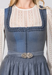 Blaues Denimkleid mit quadratischem Ausschnitt, aufwendiger Verzierung und silberner Gürtelanschnallung. Verfügt über einen plissierten Rock und transparente weiße Spitzenärmel.