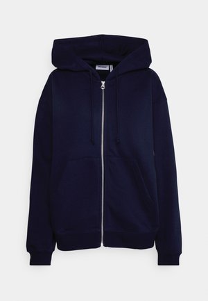 Námořnicky modrá mikina na zip z měkké bavlny, s velkou kapucí, dvěma předními kapsami a žebrovanými manžetami. Jednoduchý design bez vzorů.