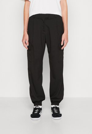 Pantaloni cargo negri cu o croială relaxată, mansete elastice, buzunare laterale și un design frontal simplu. Materialul are o textură netedă.