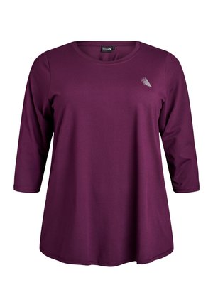 Langärmliges T-Shirt mit Rundhalsausschnitt aus dunkelviolettem Stretchstoff. Verfügt über einen kleinen metallischen Akzent auf der oberen linken Seite. Glatte Textur.