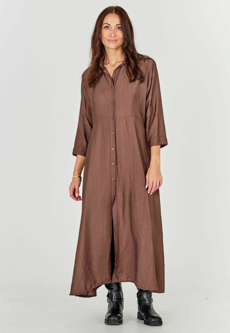 Brown, button-up maxi dress with three-quarter sleeves and textured fabric. The dress features a high-low hem and falls to mid-calf.