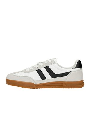 Weißer Sneaker mit niedriger Schnittform, beigen Wildledereinsätzen, schwarzen Seitenstreifen, Schnürverschluss und brauner Gummisohle.