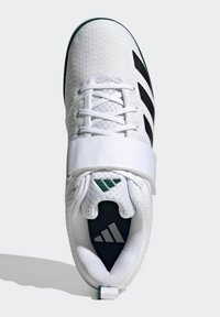 Scarpa da ginnastica bianca con tomaia texturizzata, strisce nere e una cinghia in velcro. Presenta un collare imbottito e accenti verdi sulla suola e sul logo.