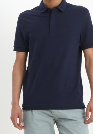 Marineblauw poloshirt van katoen, voorzien van een drieknopensluiting en een klein geborduurd logo op de borst. Korte mouwen met manchetten.