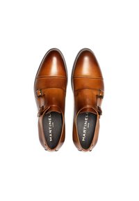 Zapatos de cuero marrón con diseño de doble hebilla, acabado pulido, puntera redondeada y plantillas negras contrastantes con el logo de la marca.