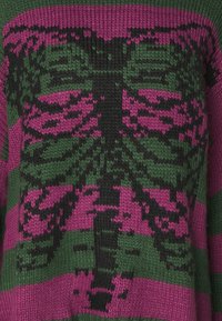 Strickpullover mit gerippter Textur in einer Farbenkombination aus Grün und Rosa. Das Design beinhaltet ein auffälliges grafisches Muster mit Streifen und Motiven.