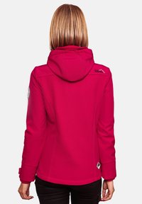 Fuchsia softshell jacket with a hood, featuring contrasting stitching and a logo on the shoulder. Designed for comfort and mobility.