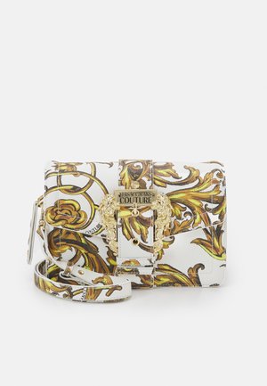 White fabric handbag with gold hardware, featuring a baroque-style yellow and brown pattern, a flap closure, and adjustable strap.