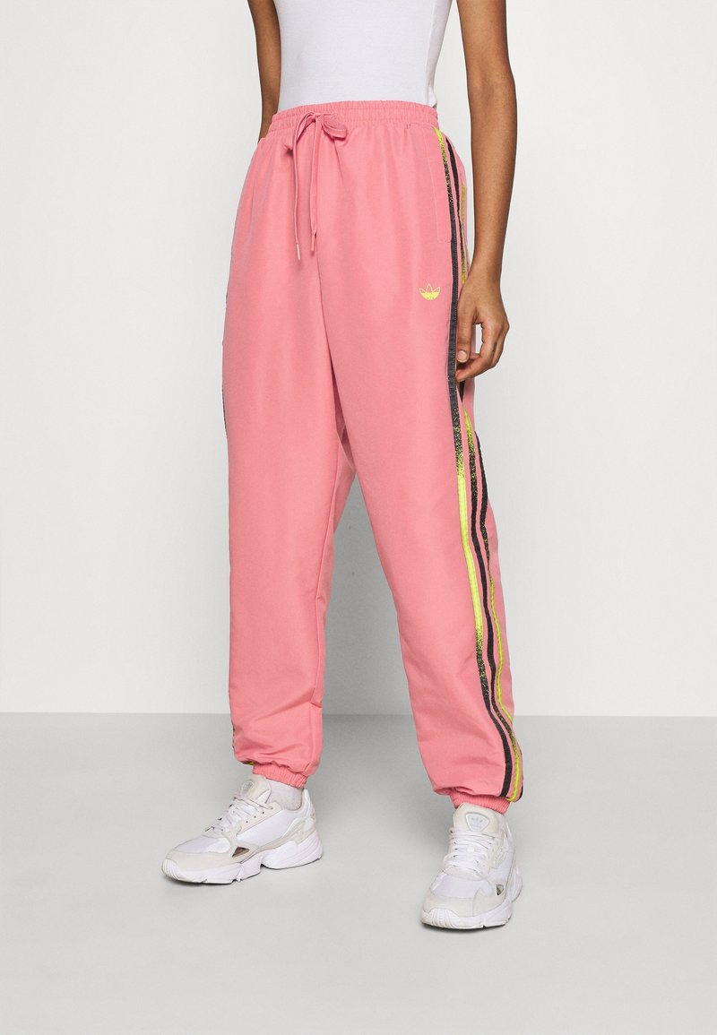 Rosa bomullsjoggers med elastiskt midjeband, prydda med svarta och neon-gula sidostreck samt en liten logotyp på framsidan.