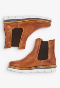 Tan leather ankle boots feature a textured side panel, elastic inserts, and a white rubber sole with a blue accent. Smooth finish throughout.
