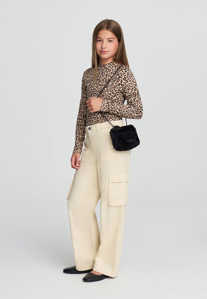 Bluzka z nadrukiem w lamparta z długim rękawem, beżowe spodnie cargo z bocznymi kieszeniami, czarna torebka krzyżowa z sztucznego futra oraz czarne baleriny.