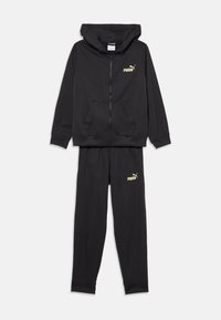 Ensemble de sport noir comprenant un sweat à capuche zippé avec une poche kangourou et un pantalon assorti, tous deux ornés d'un logo Puma jaune.