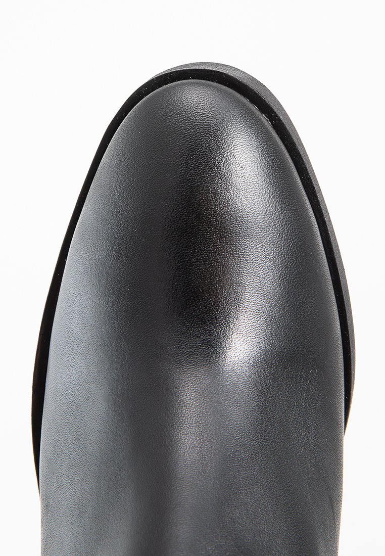 Stivale alla caviglia in pelle nera con una finitura liscia e lucida, punta arrotondata e suola piatta. Design minimalista senza hardware o decorazioni visibili.