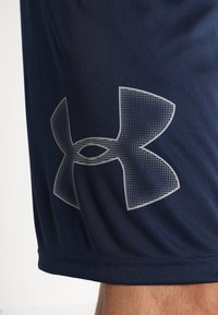 Marinekleurige sportshorts met een groot, getextureerd grijs Under Armour-logo aan de linkerkant, gemaakt van ademende stof met een soepele afwerking.