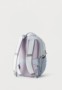 Ανοιχτό μοβ και γκρι σακίδιο πλάτης με μαξιλαρωμένους ιμάντες ώμου, χειρολαβή στην κορυφή, πλαϊνή τσέπη και ορατό φερμουάρ σε λευκό φόντο.