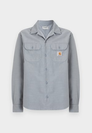 Ανοιχτόγριλο μακρυμάνικο πουκάμισο με κουμπιά, με δύο τσέπες στο στήθος, η μία με ένα μικρό ετικέτα λογότυπο Carhartt στη δεξιά πλευρά.