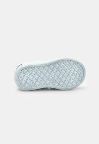 Semelle de chaussure bleu clair avec un motif en diamant texturé et des bords arrondis, offrant une finition lisse et un rebord renforcé.