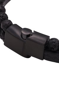 Svart lærarmbånd med teksturerte lava perler og en metallkrok, med et stilrent, moderne design som fokuserer på kontrasterende materialer.