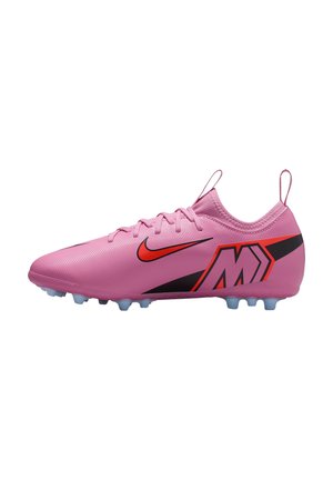 Crampons de football Nike roses avec des accents rouges et noirs, des lacets et des crampons moulés sur la semelle, montrés de côté sur un fond blanc.