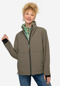 Giacca softshell verde oliva con chiusura a zip, colletto alto e due tasche frontali. Presenta accenti neri nei polsini e un rivestimento interno a contrasto.