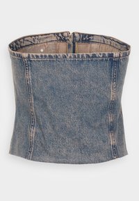 Denim-bh i blekt blå med en strukturerad passform. Har en dragkedjestängning och synliga sömnadsdetaljer längs sömmarna.