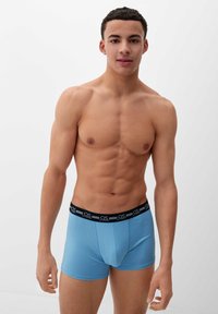 Lichtblauwe boxershorts met een zwarte elastische tailleband waarop de merknaam staat. Zachte stof, aansluitend ontwerp en midi-dij lengte.