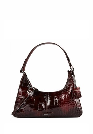 Sac à main en cuir brillant marron foncé avec texture crocodile, poignée courte, bandoulière réglable et étiquette de marque Burkely à l'avant ainsi qu'une étiquette sur le côté.