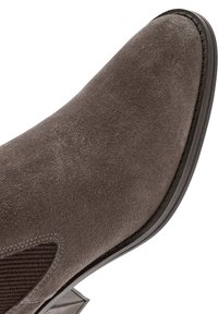 Grijze suède enkelboot met een scherpe neus en gestructureerde zijpanelen. Slanke zwarte rubberen zool en subtiele stikdetails.