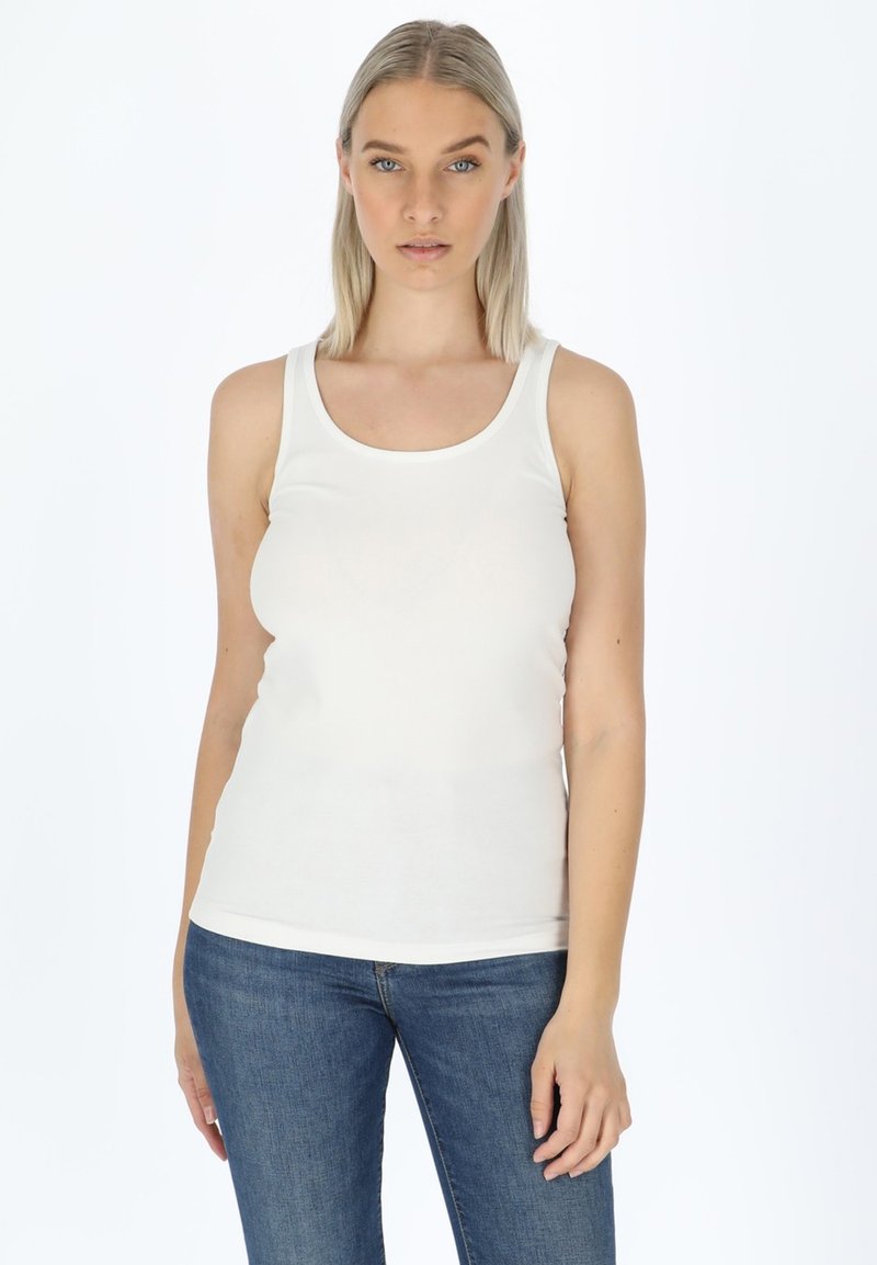 Top senza maniche bianco realizzato in un morbido tessuto misto cotone. Presenta un collo rotondo e una silhouette aderente, abbinato a jeans in denim blu.