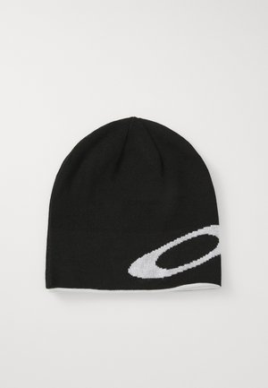 Mustat neulepipo, jossa on valkoinen abstrakti soikio muotoilu sivussa, asetettuna tasaisesti valkoista taustaa vasten.