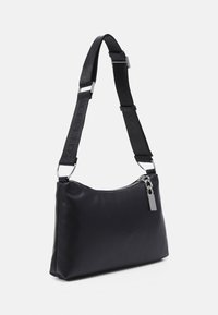 Svart axelväska med en slät, matt yta, dragkedjestängning och silverdetaljer. Justerbar rem med en texturerad tygdetalj.