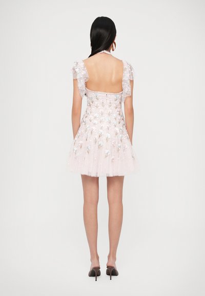 Ružové šifónové šaty s kvetinovou výšivkou, volánové rukávy, otvorené chrbát a priliehavý živôtik, ktorý sa rozširuje do rozviatej sukne. Lodičky na podpätku.