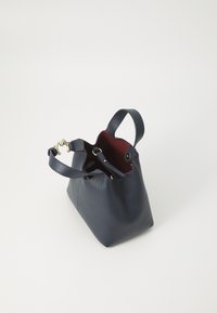 Marine leren tas met een gestructureerd oppervlak, twee handvaten en gouden hardware. Van binnen voorzien van een contrasterende rode voering. Ontwerp met open bovenkant.