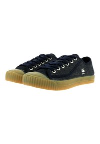 Denim sneakers with a low-top design, navy blue upper, round toe, and beige rubber sole. Features metal eyelets and textured detailing.